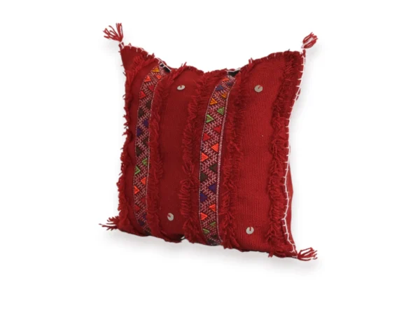 Angled view of red Moroccan Atlas Mountain wool pillow cover showing Berber tribal embroidery detail