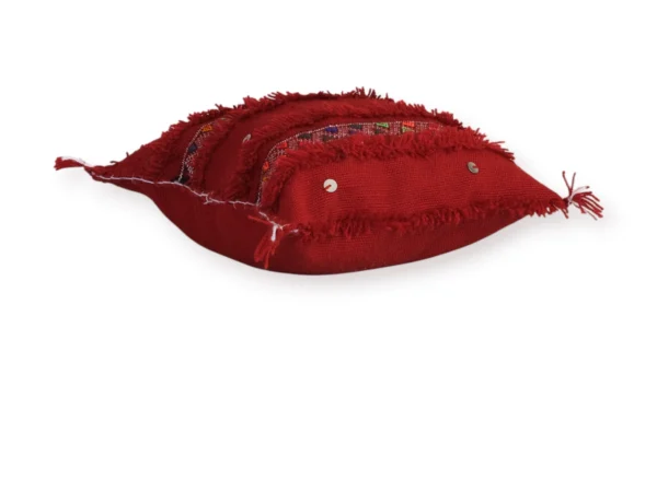 Side view of handmade Moroccan Berber wool pillow, red tribal design, Atlas Mountains, flat lay
