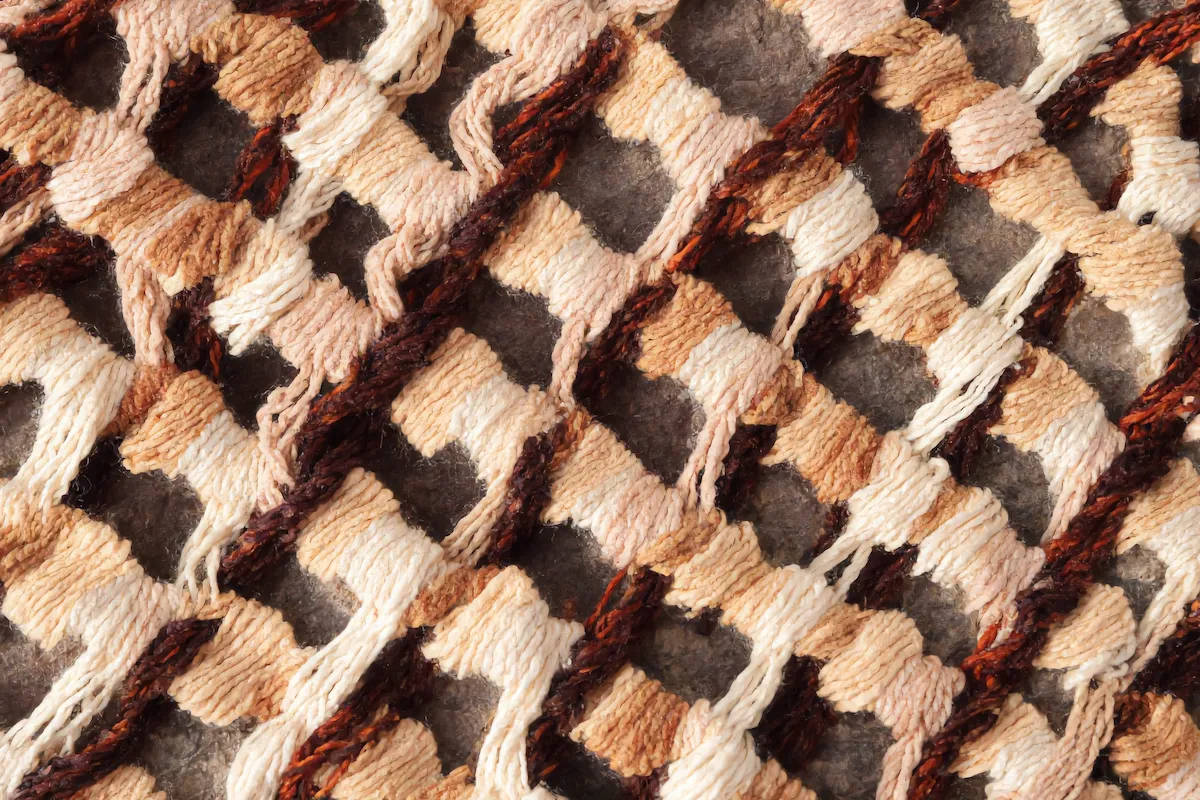 Reverse back side of an authentic hand-knotted Beni Ourain rug showing individual wool knots tied around warp threads as proof of genuine handcraft