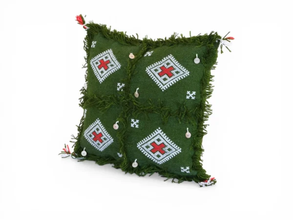 Front view of olive green Moroccan Berber wool pillow showing four red cross patterns and silver sequin charms on hand-dyed forest green wool
