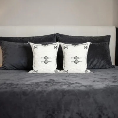White boho throw pillow on a neutral linen sofa with black and white decor