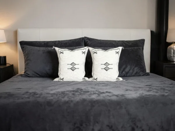 White boho throw pillow on a neutral linen sofa with black and white decor