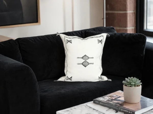 Side view of white handwoven Moroccan cactus silk pillow cover with fringe