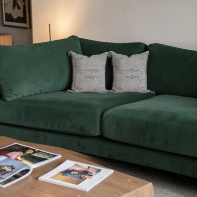 Grey Moroccan cactus silk cushions on a deep green sofa in a boho living room