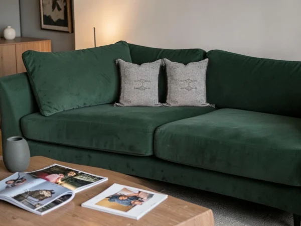 Grey Moroccan cactus silk cushions on a deep green sofa in a boho living room