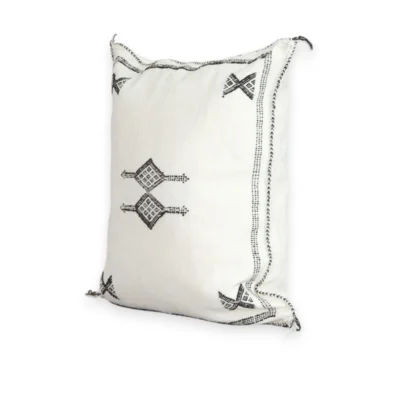 White cactus silk pillow with black Berber symbols styled on a boho sofa