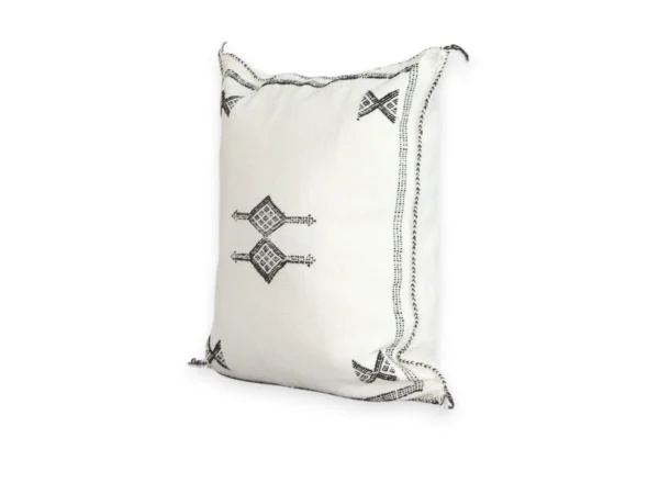White cactus silk pillow with black Berber symbols styled on a boho sofa