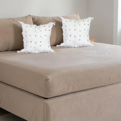 Pair of white Moroccan Handira Berber pillows styled on linen bed bohemian decor