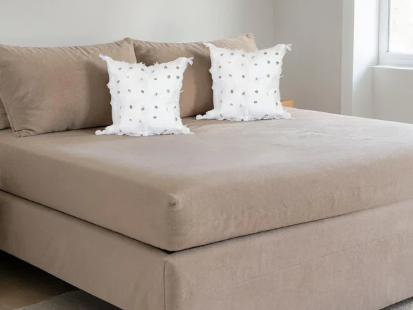 Pair of white Moroccan Handira Berber pillows styled on linen bed bohemian decor