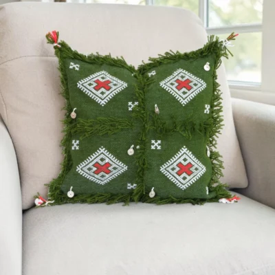 Olive green Moroccan throw pillow styled on white linen sofa in modern bohemian living room with neutral earth tone decor