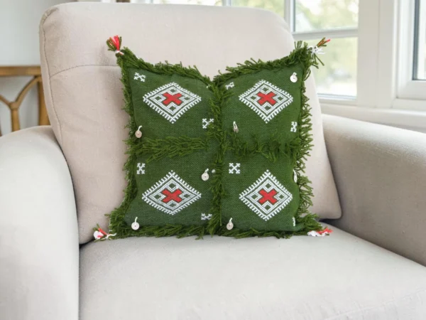 Olive green Moroccan throw pillow styled on white linen sofa in modern bohemian living room with neutral earth tone decor