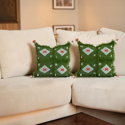 Pair of Moroccan Berber pillows including olive green and ivory styled on white sofa in layered bohemian living room