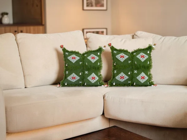 Pair of Moroccan Berber pillows including olive green and ivory styled on white sofa in layered bohemian living room