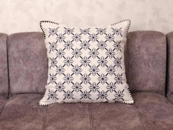 Luxury Fassi embroidered pillow 20×20 in ivory linen with all-over charcoal star pattern and sawtooth border, styled on a linen sofa – Tigemi heirloom