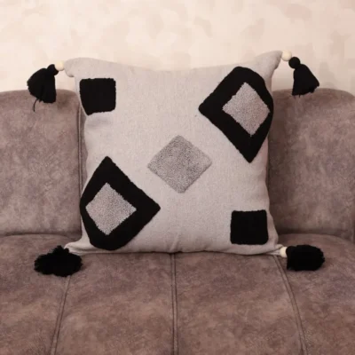 Hand-tufted Berber cushion cover in ivory and black with diamond geometric motifs and corner tassels – boho Moroccan home decor