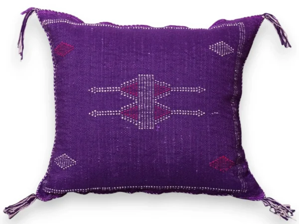 Studio view of an amethyst purple sabra silk throw pillow showing a Berber arrow cross totem, scattered diamond motifs and corner tassels on a white background