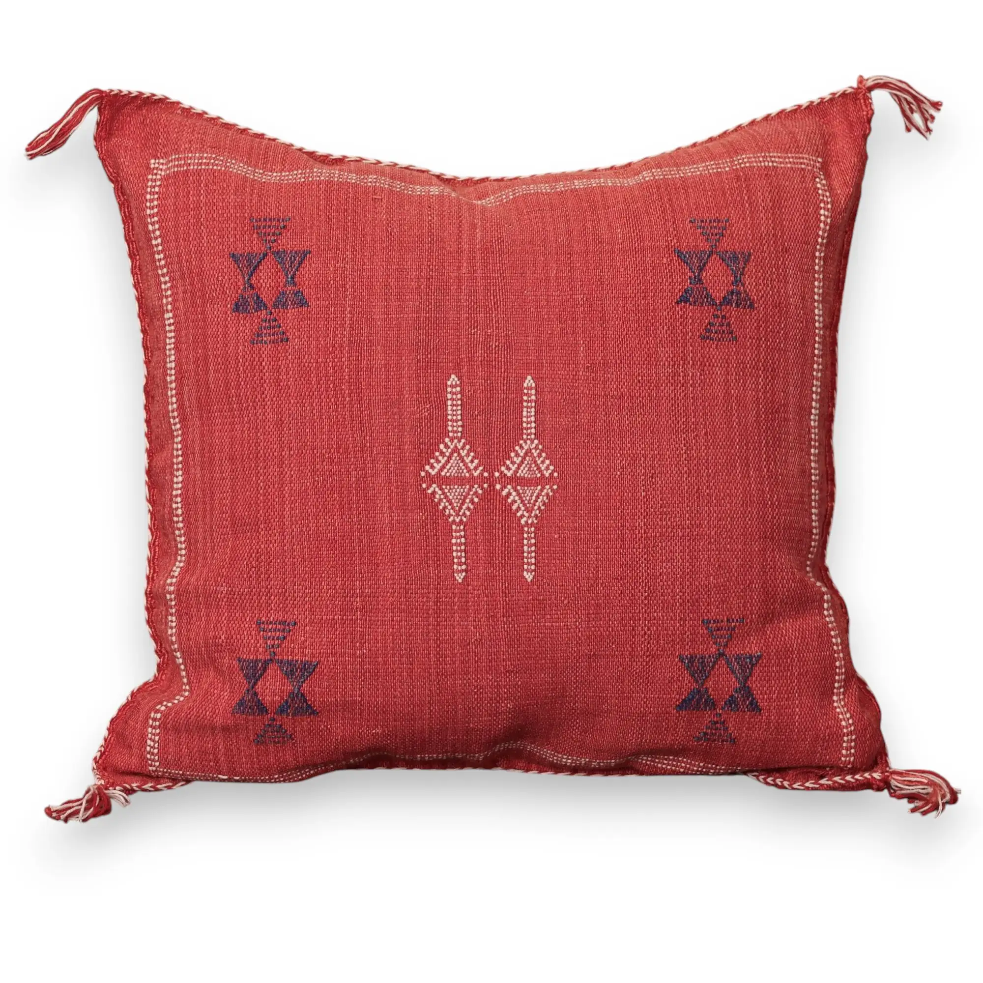 Handwoven coral red sabra cactus silk throw pillow with a navy blue Berber twin dagger motif at the center and navy chalice star motifs in the corners