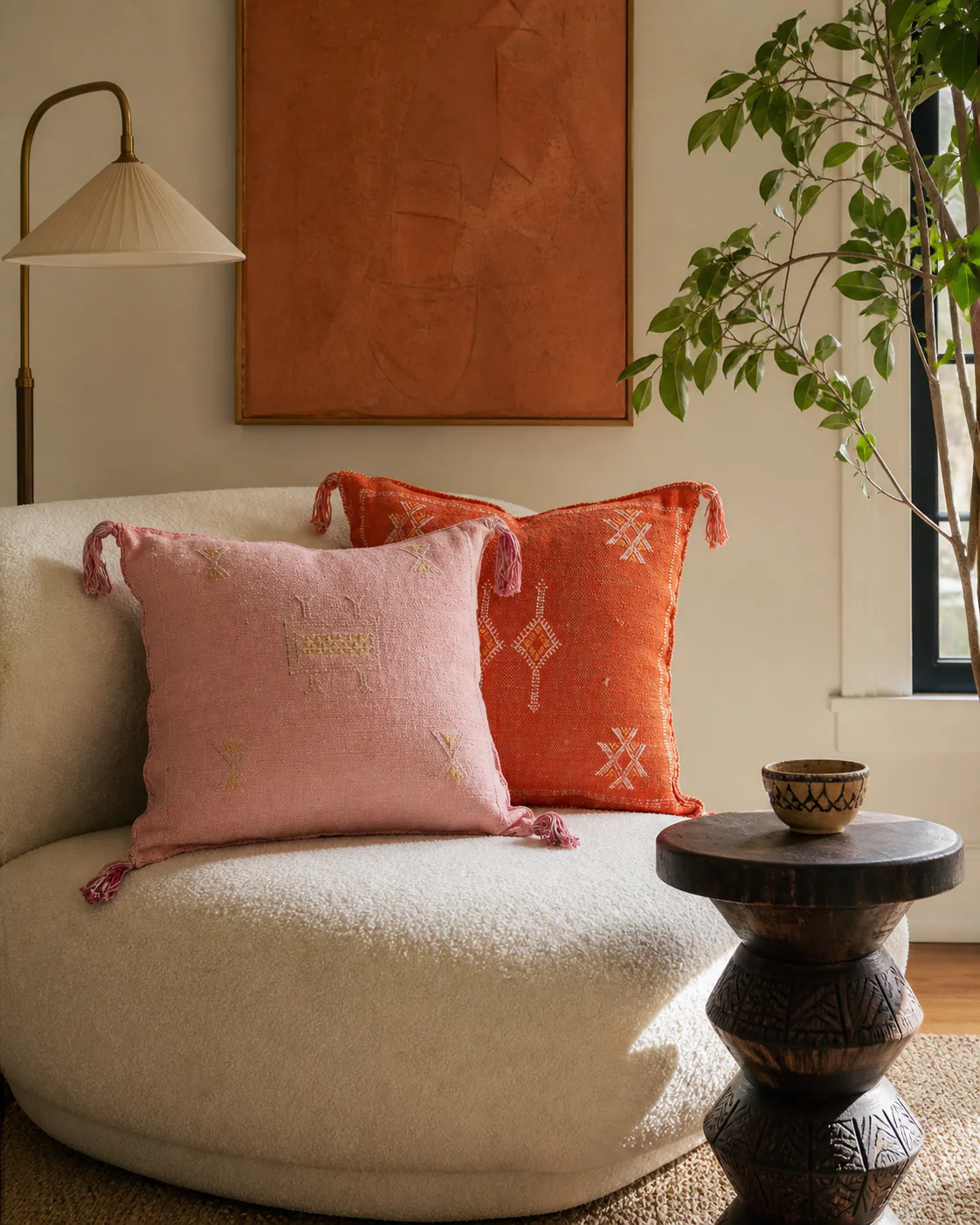 Small Afrohemian living room with blush and burnt-orange handwoven Moroccan pillows